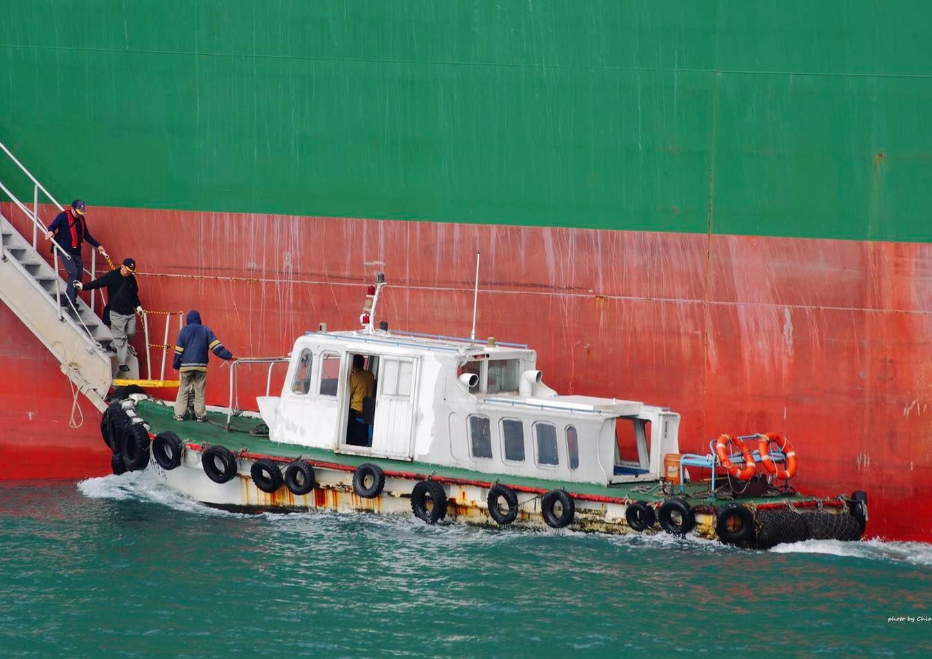 The pilot takes a tender boat to approach the ship that needs to be piloted (close view)