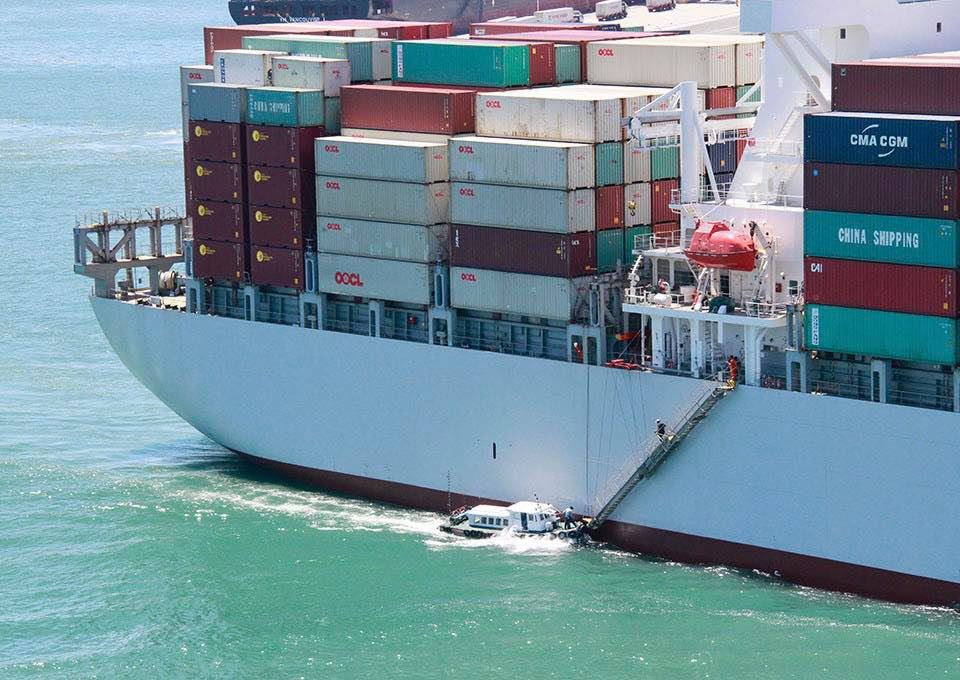 The pilot takes a tender boat to approach the ship that needs to be piloted (far view)